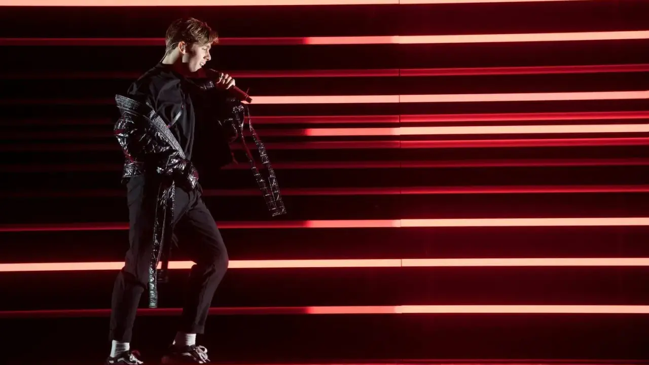 Benjamin Ingrosso på scenen med rött ljus som bakgrund, redo för Eurovision.