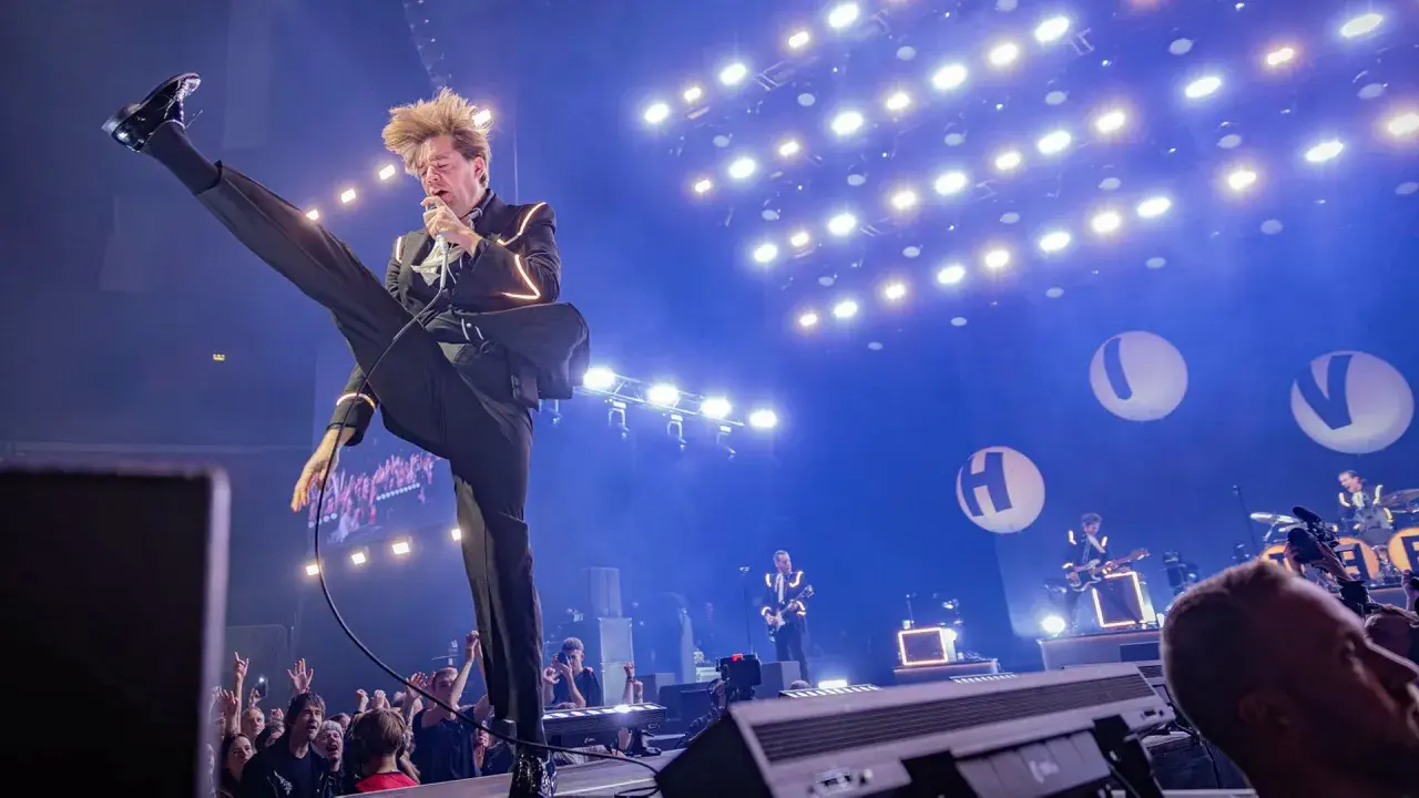 Pelle Almqvist i The Hives levererar en energisk show. Publiken jublar under konserten, en perfekt recension av bandets liveframträdande.