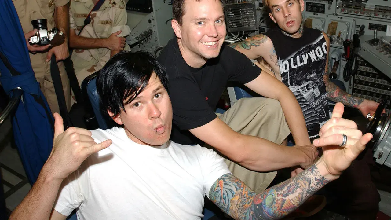Mark Hoppus, Tom DeLonge och Travis Barker från Blink-182 i Sverige. De poserar med tatueringar och glada miner.