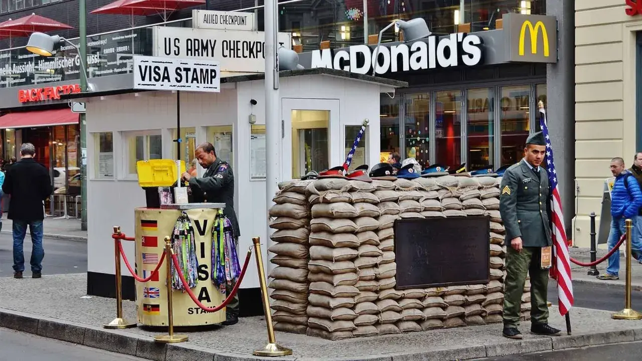 Checkpoint Charlie, ett måste att se i Berlin, med soldater och en McDonald's i bakgrunden.