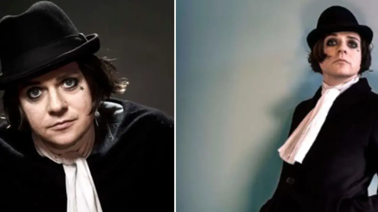Henrik Berggren, Broder Daniel, bär svart hatt och vit scarf. Mörk makeup runt ögonen.