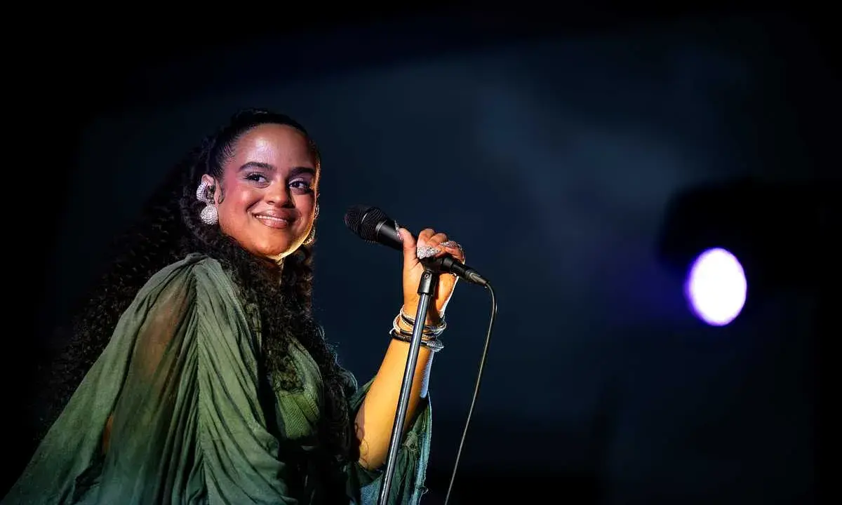 Seinabo Sey njuter av att uppträda på en konsert, med ett leende och mikrofonen i handen.