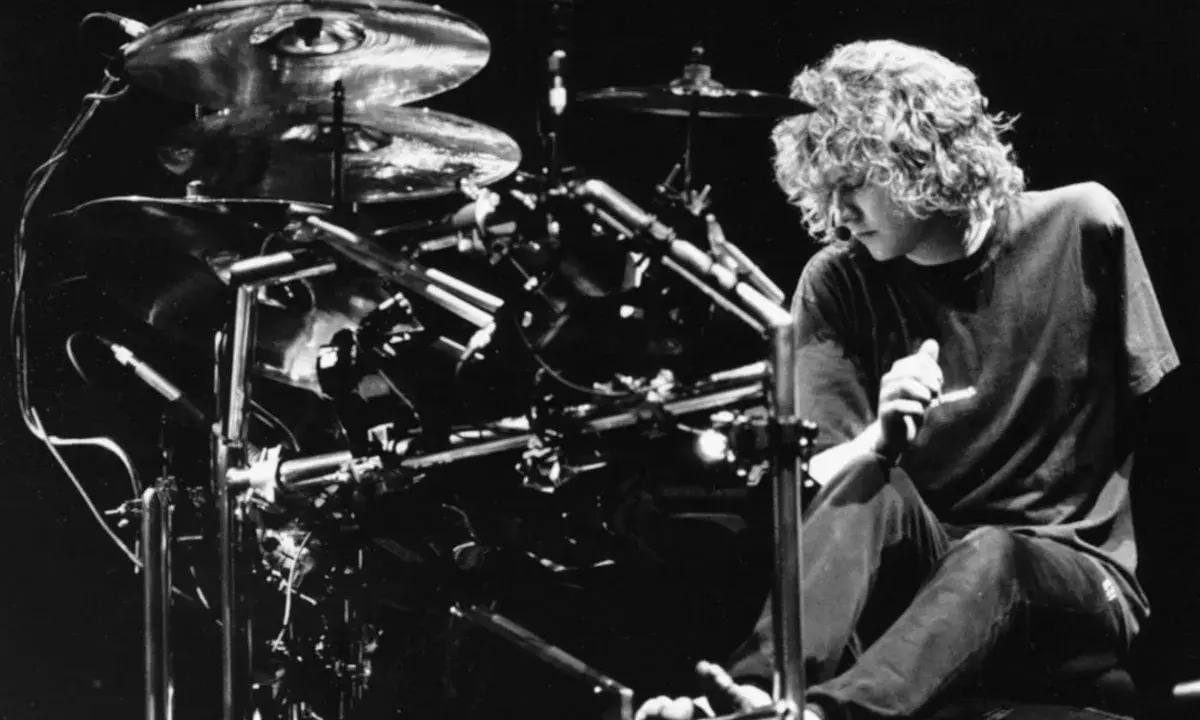 Def Leppard trummis Rick Allen sitter vid sitt trumset, redo att leverera en kraftfull rytm.