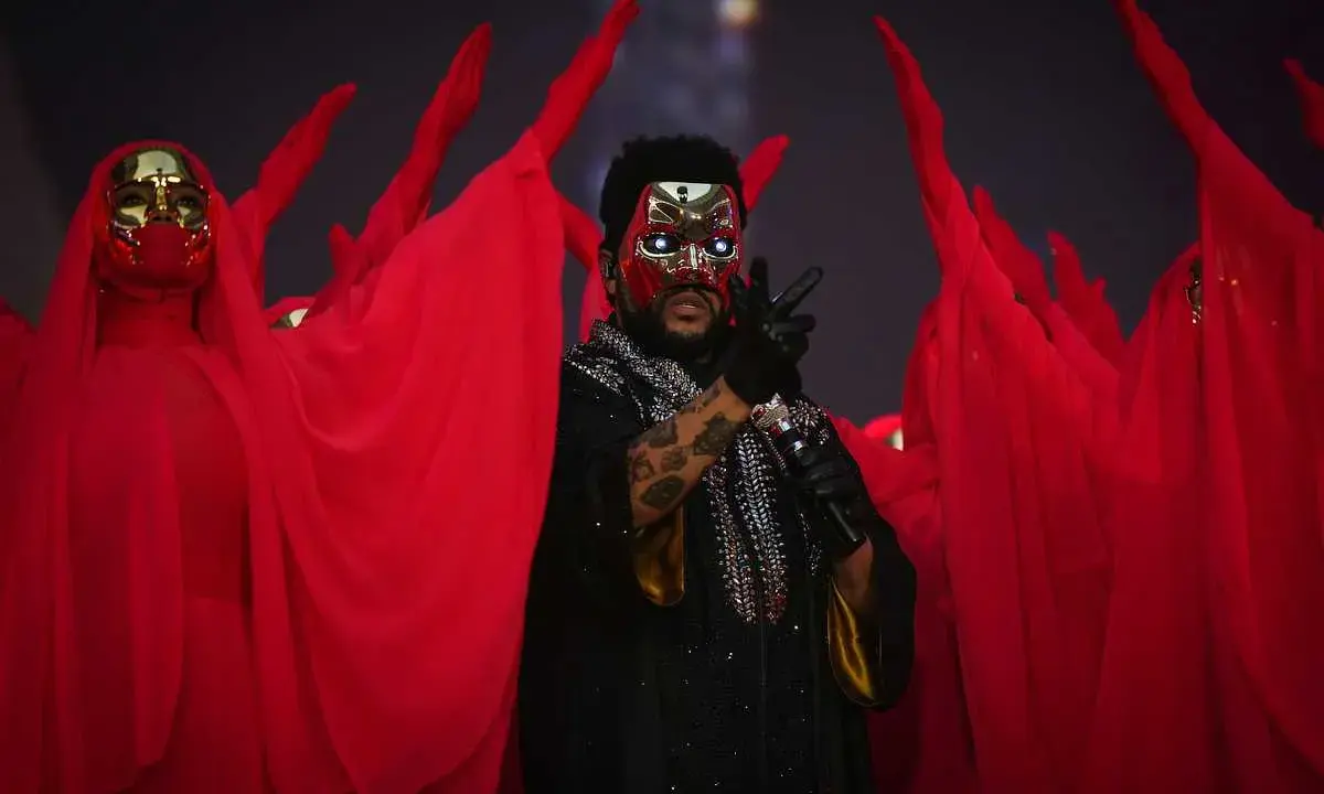 The Weeknd Sverige: artisten med mask och röda dansare på scen.
