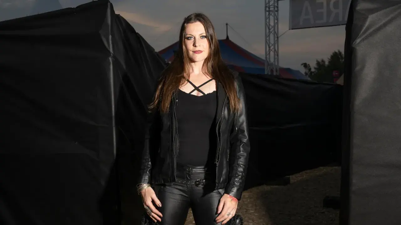 Floor Jansen, klädd i svart skinn, står framför en cirkustält. Hon pratar svenska.