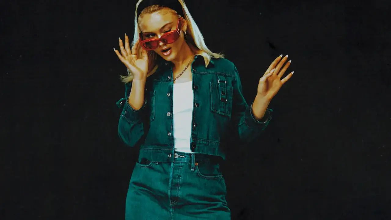 Zara Larsson 2024 i en snygg denim-outfit med röda solglasögon, redo att ta världen med storm.