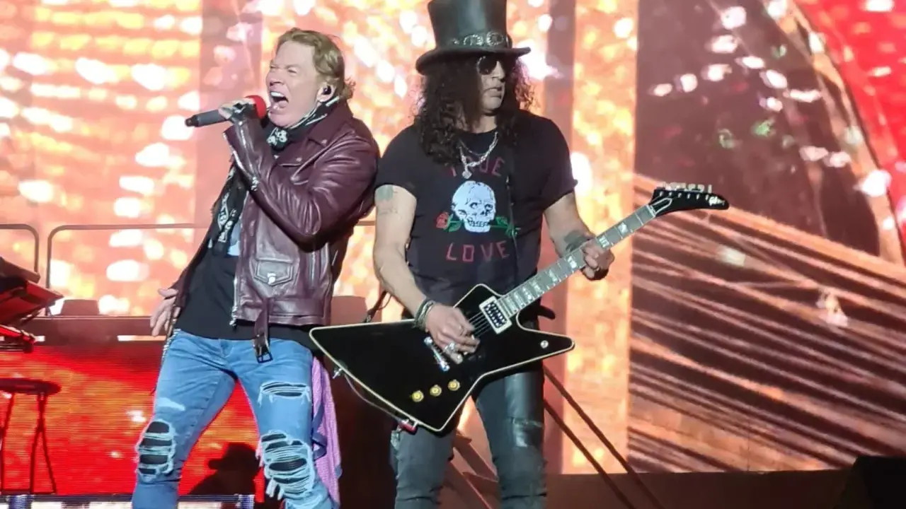 Axl Rose sjunger med Guns N' Roses i Sverige. Slash spelar gitarr med sin ikoniska hatt.