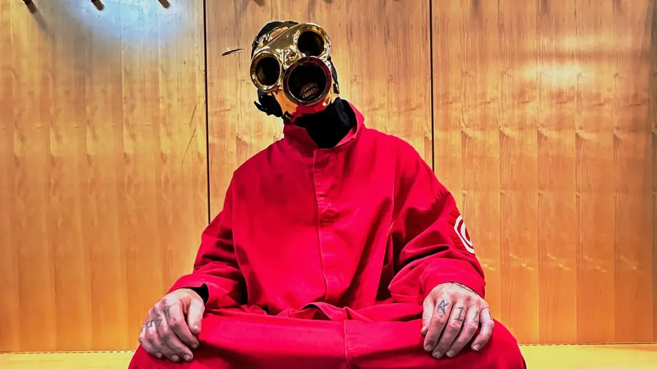 Sid Wilson i Slipknot sitter i en röd overall med en unik mask.