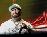 50 Cent på scen i Sverige, med en stor kedja och keps.