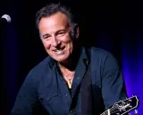 Bruce Springsteen ler glatt på scenen i Sverige, med gitarr och mikrofon redo för en oförglömlig kväll.