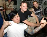 Mark Hoppus, Tom DeLonge och Travis Barker från Blink-182 i Sverige. De poserar med tatueringar och glada miner.
