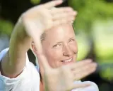Regina Lund ler inramad av sina händer, som om hon skapar en scen för en film.