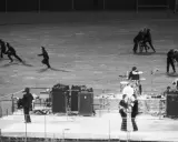 En kaotisk scen med figurer som springer, kanske en representation av The Beatles sista spelning.