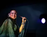 Seinabo Sey njuter av att uppträda på en konsert, med ett leende och mikrofonen i handen.