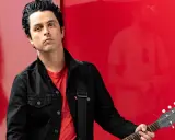 Billie Joe Armstrong, green day sångare, med sin Gibson Les Paul gitarr mot en röd bakgrund.