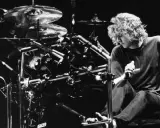 Def Leppard trummis Rick Allen sitter vid sitt trumset, redo att leverera en kraftfull rytm.