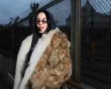 Miriam Bryant, fotograferad av David Larsson, bär en lyxig pälsjacka och solglasögon.