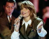 Carola sjunger, en av de svenska bidrag som vunnit Eurovision. Hon håller en mikrofon och gestikulerar.