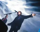 Robert Smith sjunger med utsträckta armar under The Cure i Stockholm.