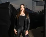 Floor Jansen, klädd i svart skinn, står framför en cirkustält. Hon pratar svenska.