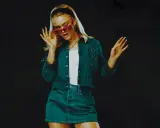 Zara Larsson 2024 i en snygg denim-outfit med röda solglasögon, redo att ta världen med storm.