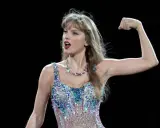 Taylor Swift flexar armen i en glittrig outfit. Undrar du hur mycket kostar Taylor Swift biljetter?