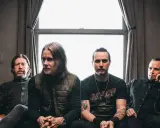 Alter Bridge Sverige: bandmedlemmar sitter på en soffa framför ett fönster.