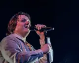 Lewis Capaldi sjunger passionerat på scen i Sverige, med mikrofonen i handen och blicken uppåt.
