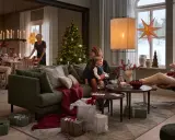 En familj njuter av en mysig julkväll med en sprakande brasa med lugn julmusik. Presenter och julgran bidrar till stämningen.