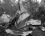 Vraket av ett flygplan i skogen, en man står bredvid. En tragisk påminnelse om lynyrd skynyrd flygolycka.