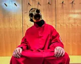 Sid Wilson i Slipknot sitter i en röd overall med en unik mask.