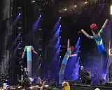 The Offspring Sverige spelar live med uppblåsbara figurer på scenen. Blå ljus och rök skapar en festlig stämning.