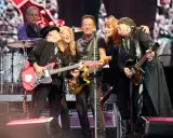 Medlemmar av E Street Band på scen, med Bruce Springsteen i mitten, omgiven av bandmedlemmar som spelar gitarr.