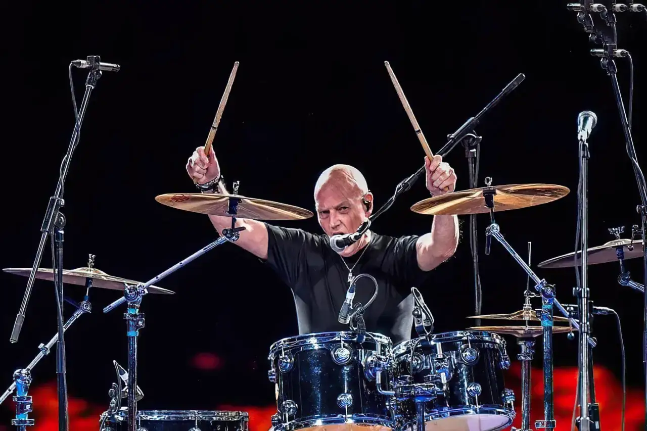 AC/DC trummis Phil Rudd i full aktion, med trumpinnarna högt lyfta.