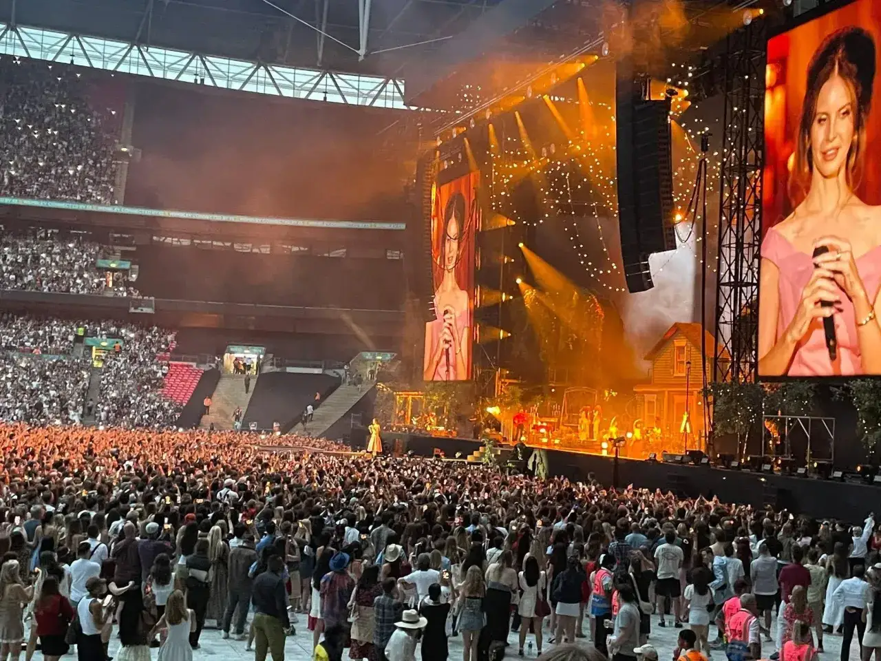 Stor publik på konsert med Lana Del Rey i Stockholm. Hon står på scenen, belyst av starka lampor.