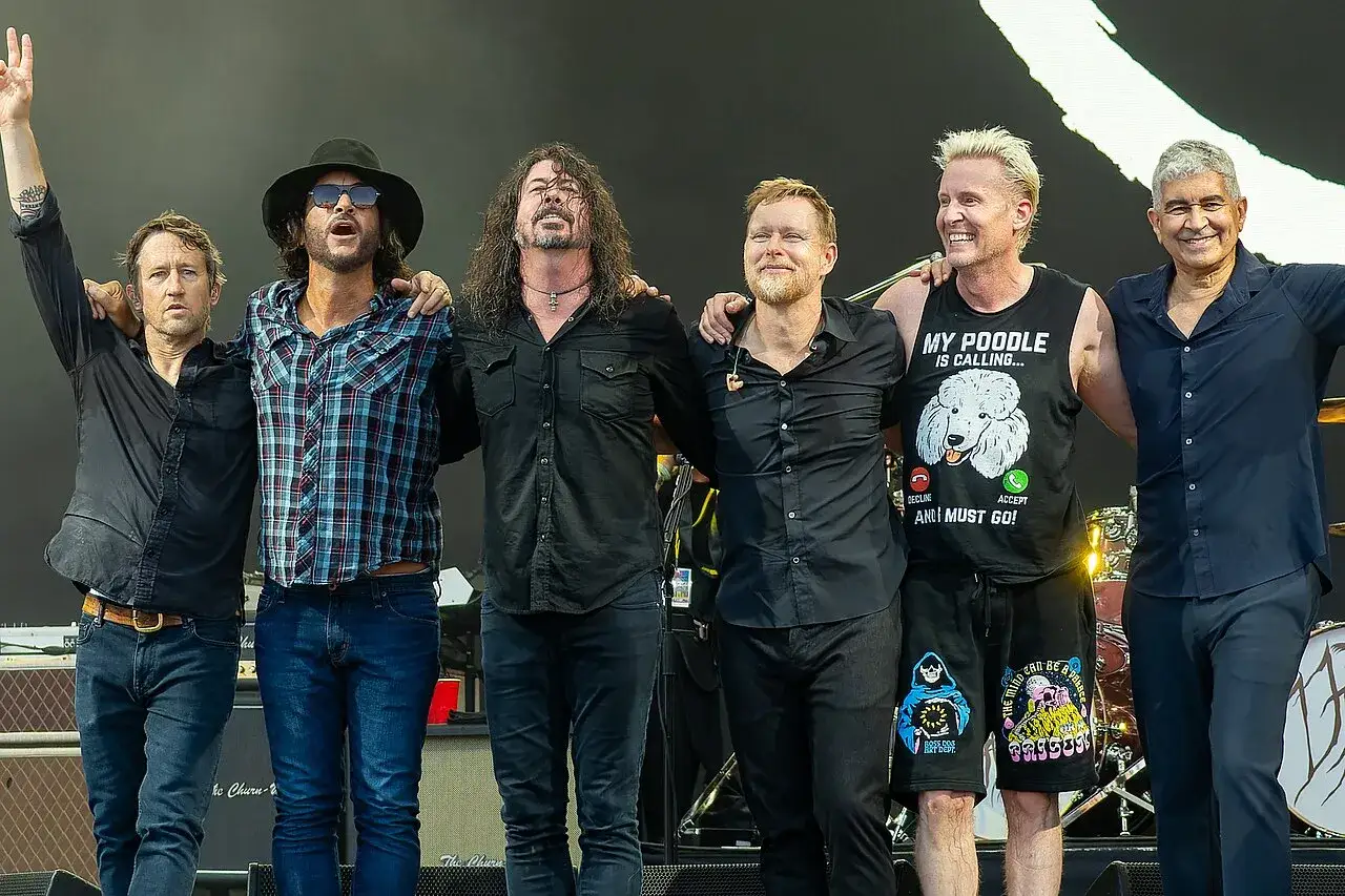 Medlemmar av Foo Fighters poserar tillsammans på scen.