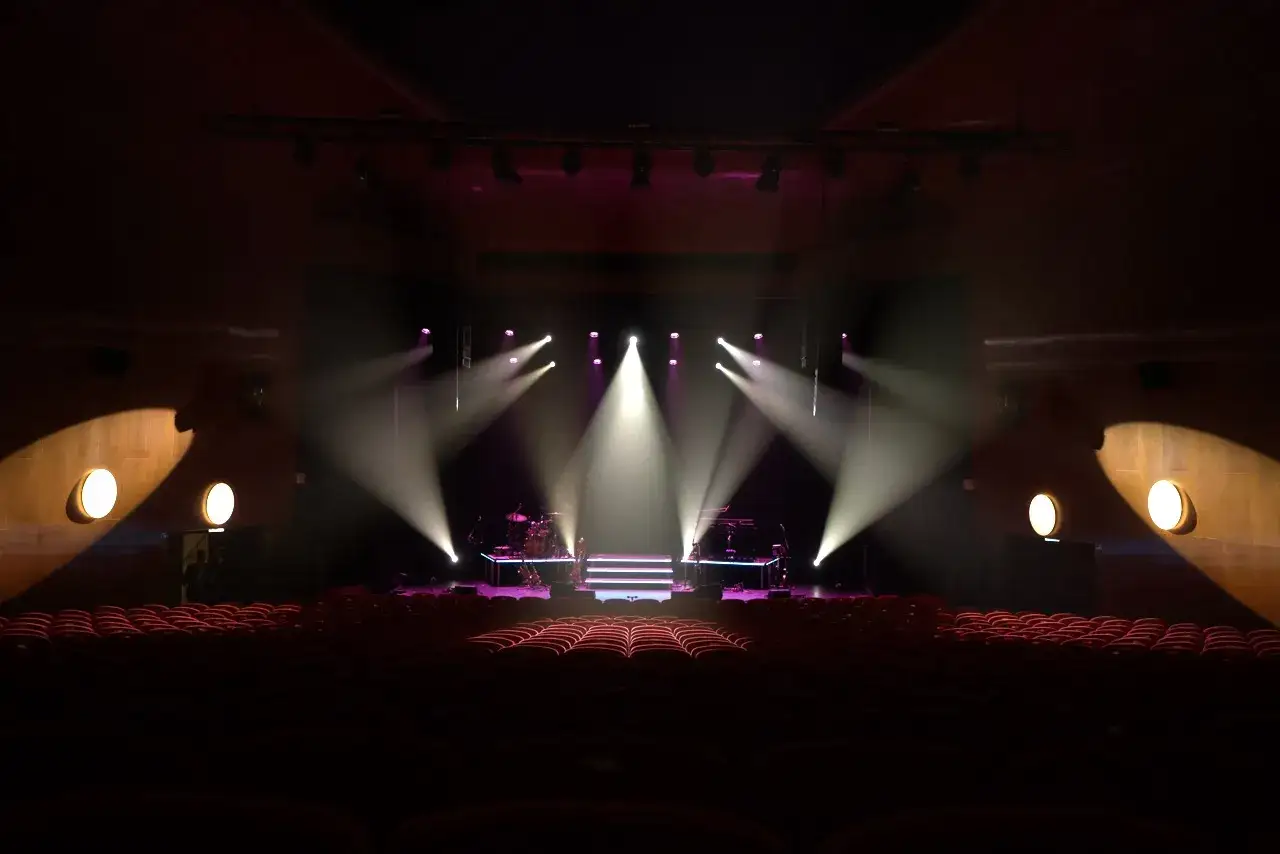 Tom scenen är upplyst av starka strålkastare, redo för en konsert med Erik Meduza.