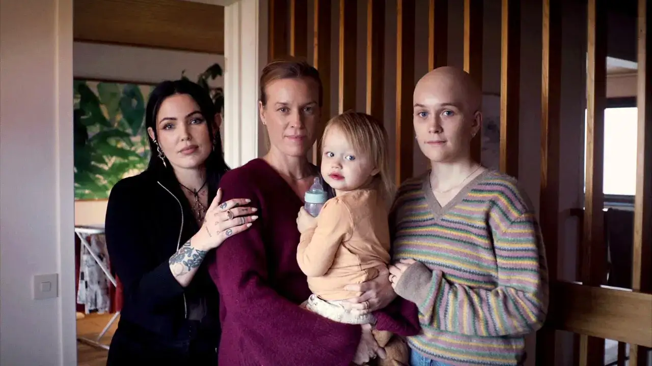 David Larsson och Miriam Bryant med familj. En kvinna håller ett barn, en annan kvinna med rakad skalle och en fjärde kvinna står bredvid.