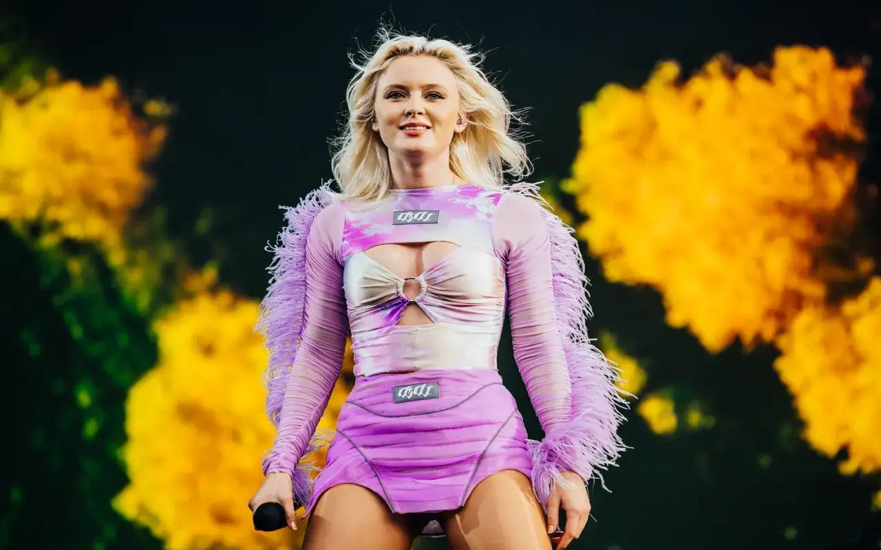 Zara Larsson konsert i en lila och rosa outfit med fjädrar.