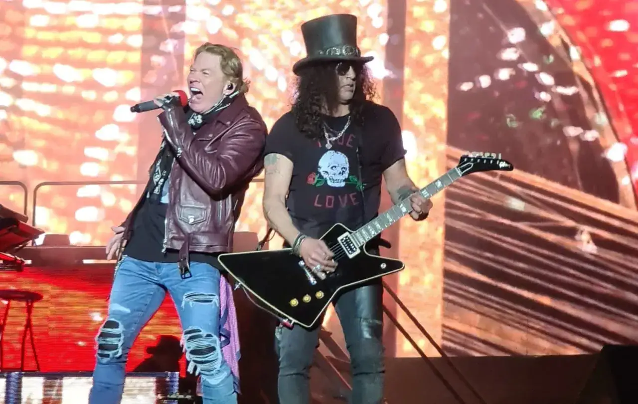 Axl Rose sjunger med Guns N' Roses i Sverige. Slash spelar gitarr med sin ikoniska topphatt.