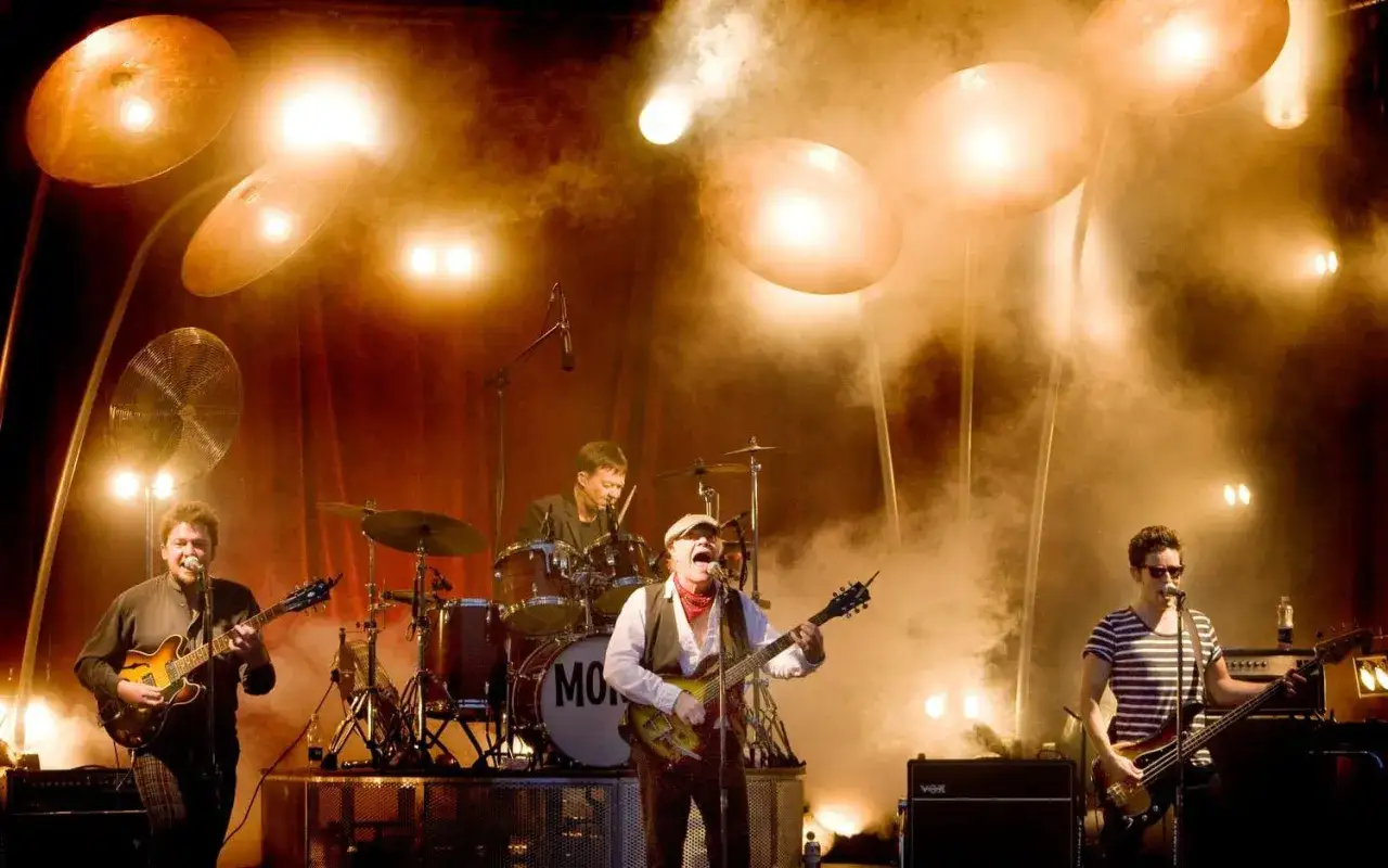 Alice Eva Larsen och hennes band spelar på scenen, omgivna av rök och starka strålkastare.