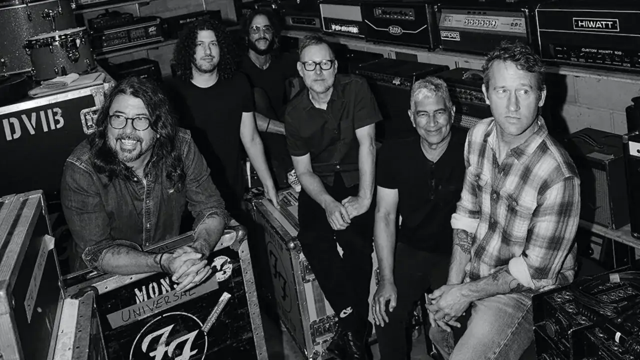 Foo Fighters trummis och bandmedlemmar poserar bland utrustning.