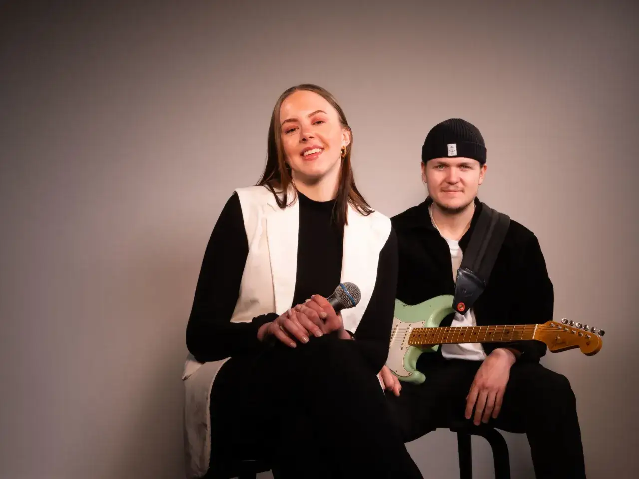 En kvinna med mikrofon och en man med gitarr, redo att leverera en magisk Fibes oh Fibes-show.