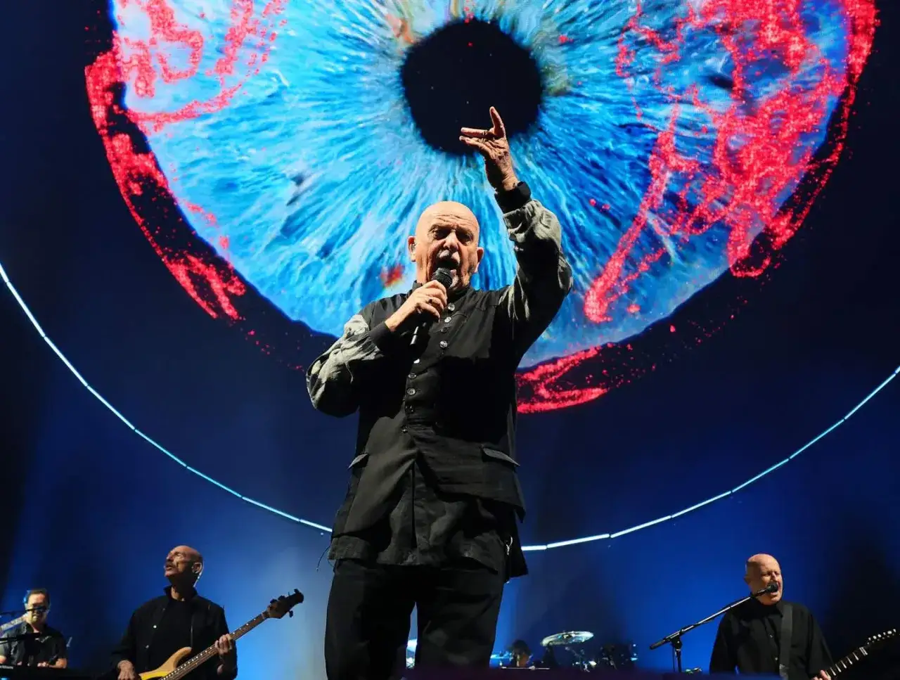 Peter Gabriel sjunger live med en gigantisk iris som bakgrund, kanske för att fira sitt peter gabriel new album.