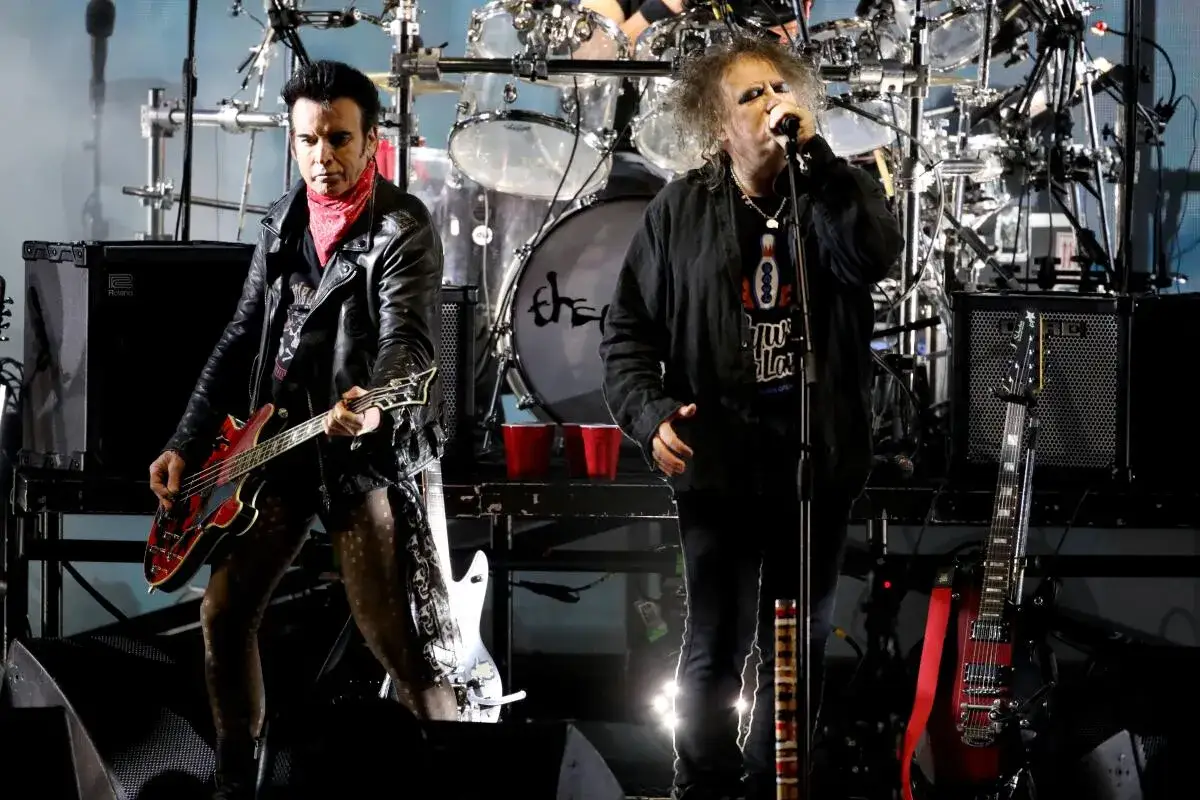Medlemmar av The Cure på scen, med basisten till vänster och sångaren till höger.