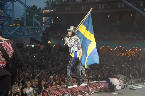 Alice Cooper i Sverige, med svensk flagga och en stor publik som filmar.